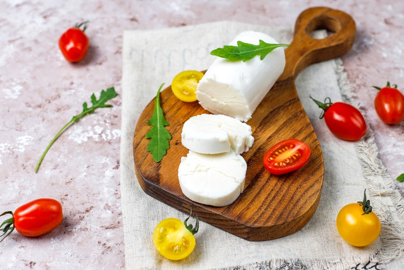 goat-cheese-slices-on-wooden-board-with-ruccola-cherry-tomatoes-ready-to-eat.jpg