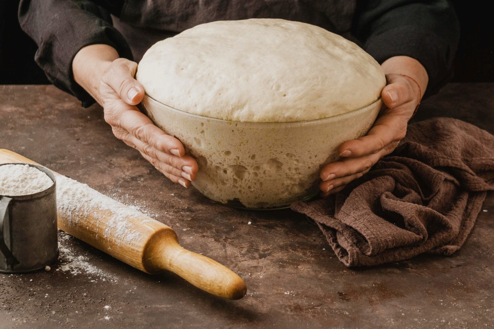 female-chef-holding-bowl-with-pizza-dough.jpg