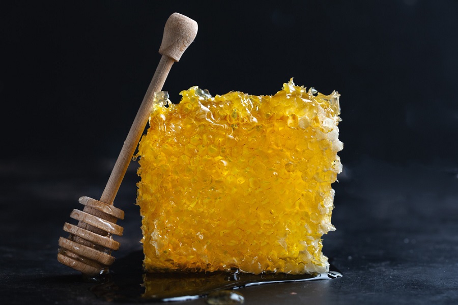 honeycombs-with-fresh-honey-and-honey-spoon-on-dark-background-closeup.jpg