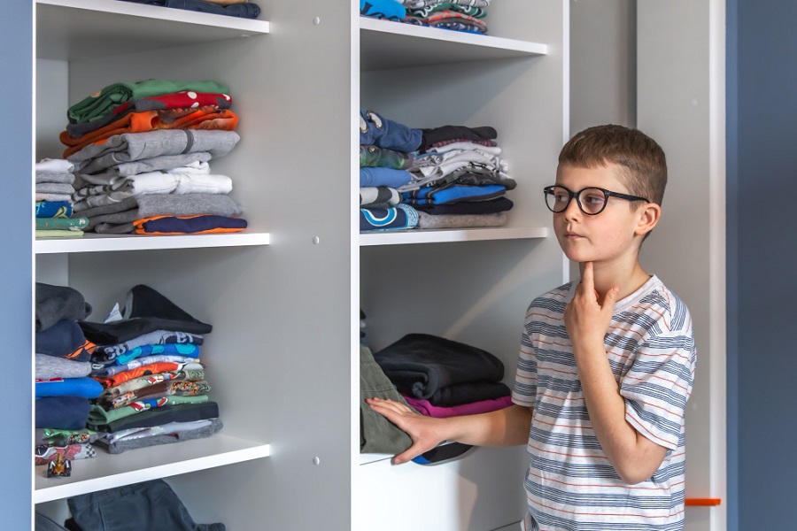 a-cute-boy-with-glasses-stands-near-a-wardrobe-and-thinks-about-what-to-wear.jpg